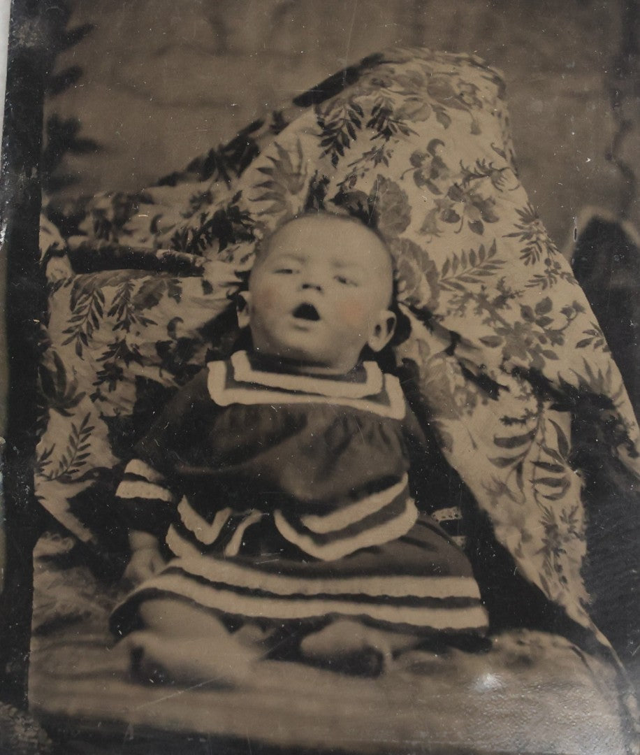 Lot 105 - Antique Hidden Mother Tintype Photograph Of Baby With Mouth Agape, Seated With Mother Or Assistant Conspicuously Concealed Beneath Floral Blanket Behind Baby