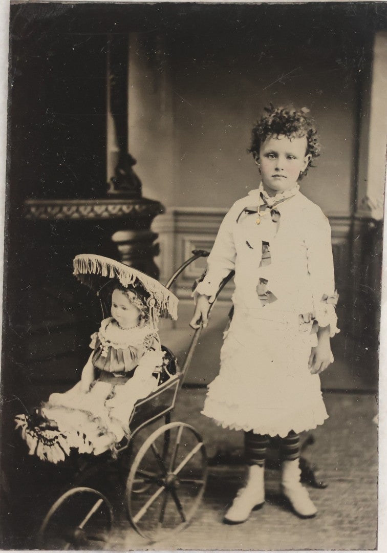Lot 107 - Antique Tintype Photograph Of Curly-Haired Girl Standing Beside Pram With Large Toy Doll
