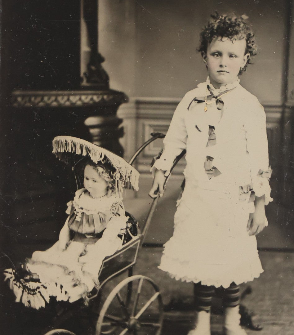 Lot 107 - Antique Tintype Photograph Of Curly-Haired Girl Standing Beside Pram With Large Toy Doll