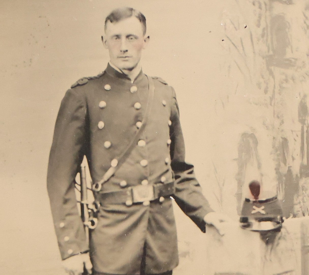 Lot 108 - Antique Tintype Photograph Of Uniformed Militiaman In Double-Breasted Coat With Shoulder Scales And Sword, Kepi On Pedestal, In Studio Setting