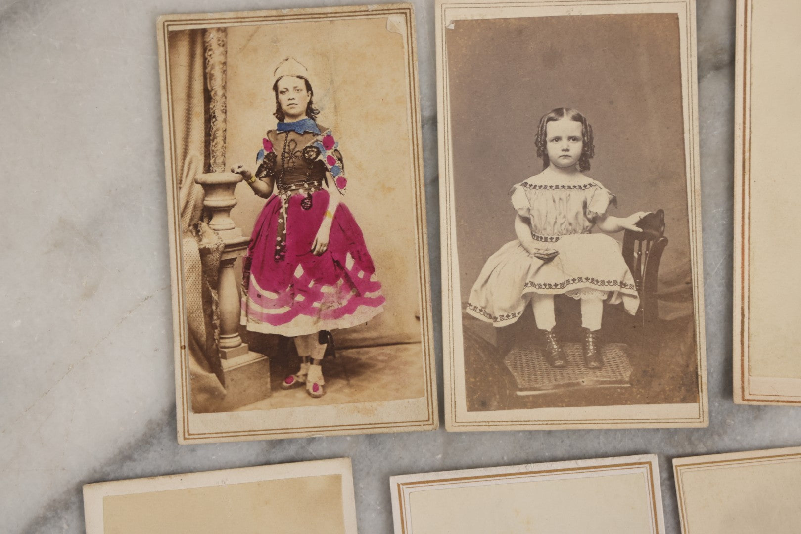 Lot 127 - Grouping Of Eleven Antique Carte De Visite C.D.V.. Photographs Including Hand-Colored Portrait Of Young Girl In Traditional Dress, Boy In Chair, Girl In Dress, And Multiple Men's Portraits