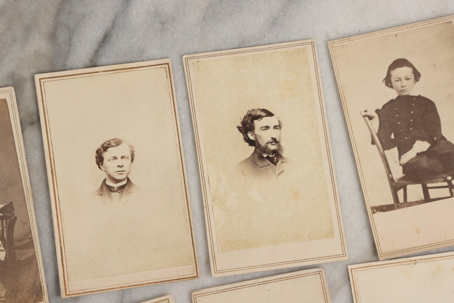 Lot 127 - Grouping Of Eleven Antique Carte De Visite C.D.V.. Photographs Including Hand-Colored Portrait Of Young Girl In Traditional Dress, Boy In Chair, Girl In Dress, And Multiple Men's Portraits