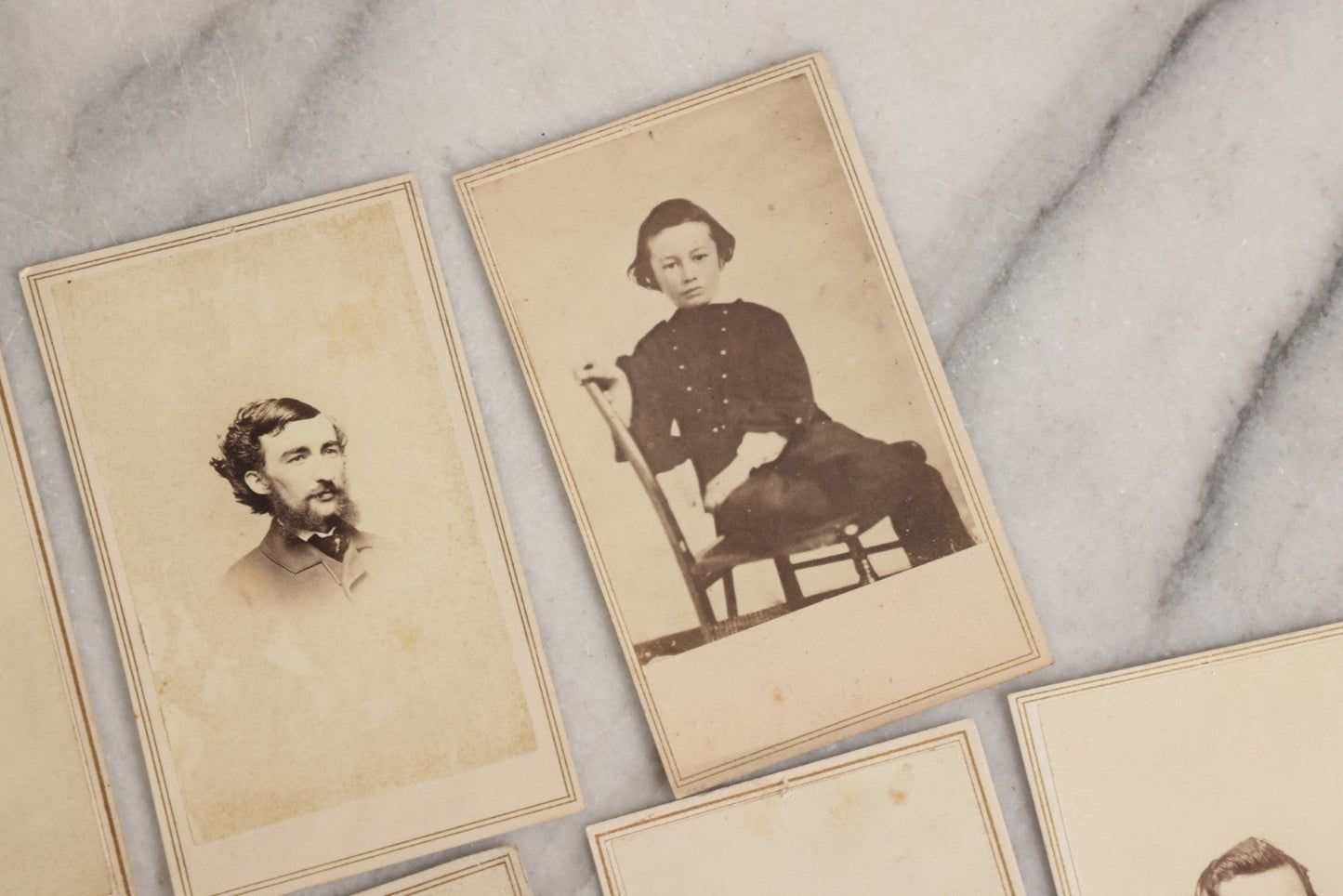 Lot 127 - Grouping Of Eleven Antique Carte De Visite C.D.V.. Photographs Including Hand-Colored Portrait Of Young Girl In Traditional Dress, Boy In Chair, Girl In Dress, And Multiple Men's Portraits