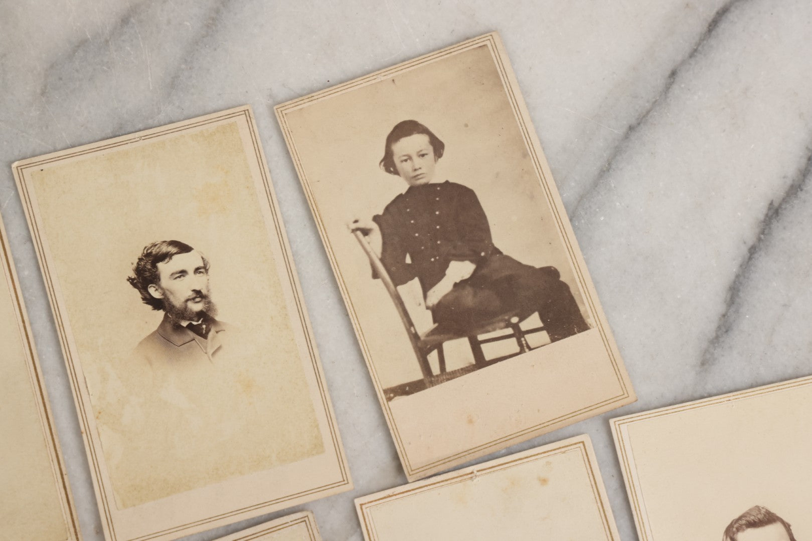 Lot 127 - Grouping Of Eleven Antique Carte De Visite C.D.V.. Photographs Including Hand-Colored Portrait Of Young Girl In Traditional Dress, Boy In Chair, Girl In Dress, And Multiple Men's Portraits