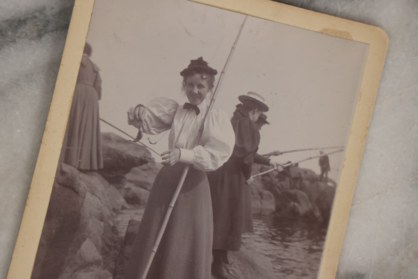 Lot 128 - Grouping Of Five Antique Outdoor Boarded Photographs, Victorian Era, Including Woman Fishing July 1896; Three Women Seated On Rocky Shore; Large Group With Dog June 1896; Ladies Posed On Porch Of “Chase Cabin”; And Group With Dog