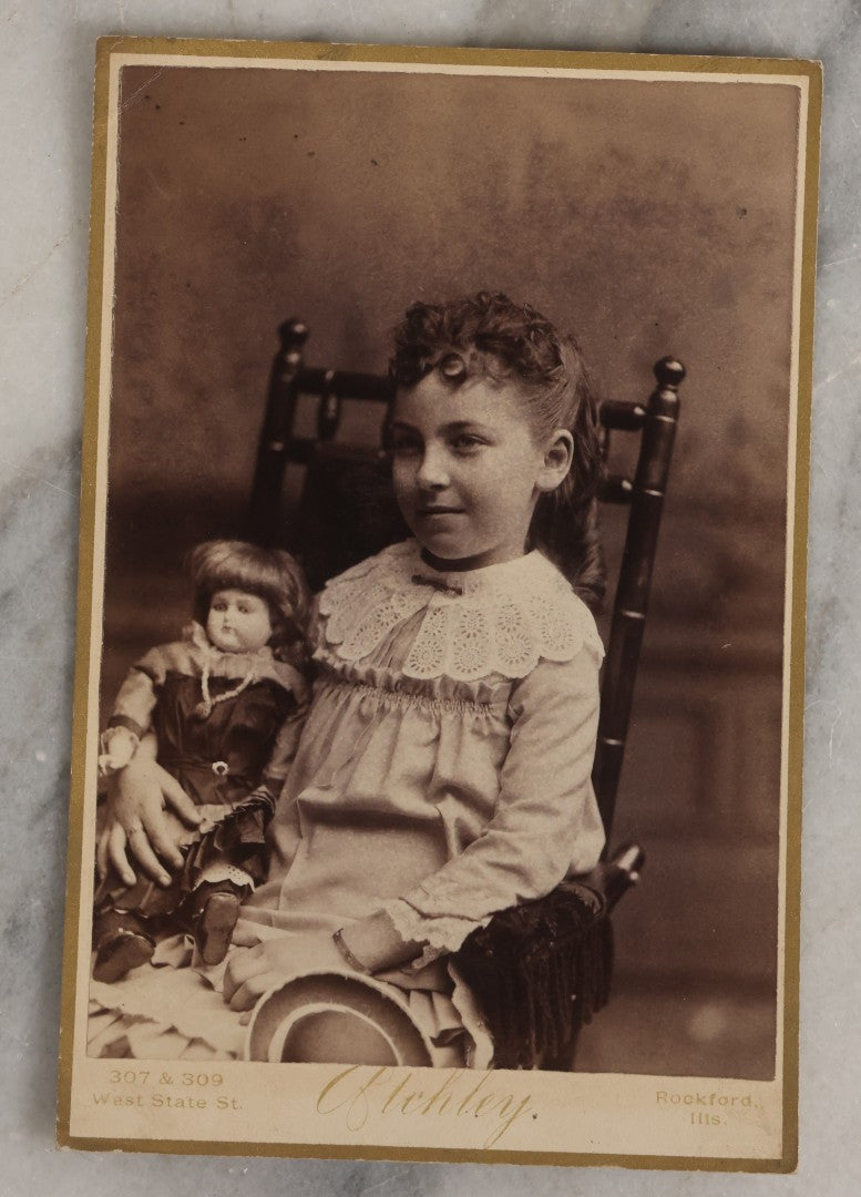 Lot 132 - Antique Cabinet Card Photograph Of Little Girl Posing With China Head Doll, Photographed By Oflehley, Rockford, Illinois