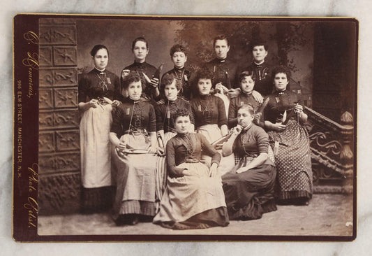 Lot 133 - Antique Cabinet Card Photograph Of Twelve Women Posed With Sewing Tools And Apparatus, Including Thread, Bobbins, And Scissors, Photographed By O. Desmarais, 999 Elm Street, Manchester, New Hampshire