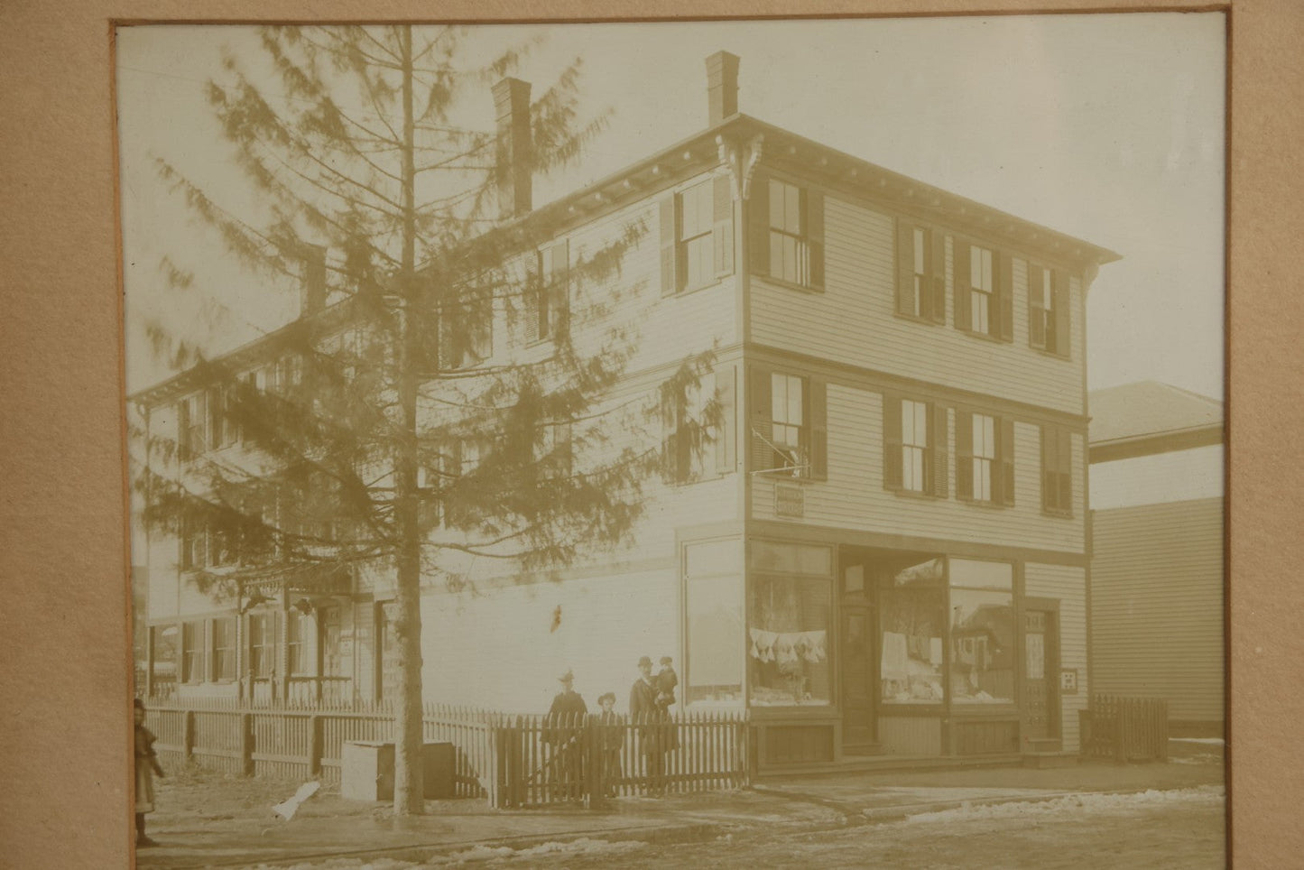 Lot 135 - Antique Framed Photograph Of Multi‑Story Wooden Storefront With Signage Alexstrom Skräddare ("Tailor"), Annotated On Reverse As Bystrom Family's “First Home In America – Greenwood St. Next To Lutheran Church” Dated 1896, 13-3/4" x 11-3/8"