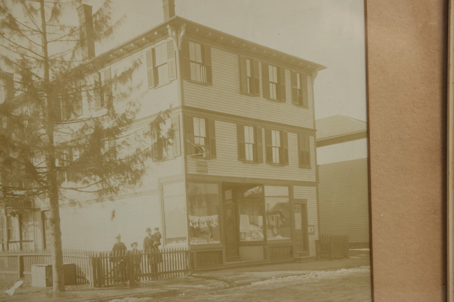Lot 135 - Antique Framed Photograph Of Multi‑Story Wooden Storefront With Signage Alexstrom Skräddare ("Tailor"), Annotated On Reverse As Bystrom Family's “First Home In America – Greenwood St. Next To Lutheran Church” Dated 1896, 13-3/4" x 11-3/8"