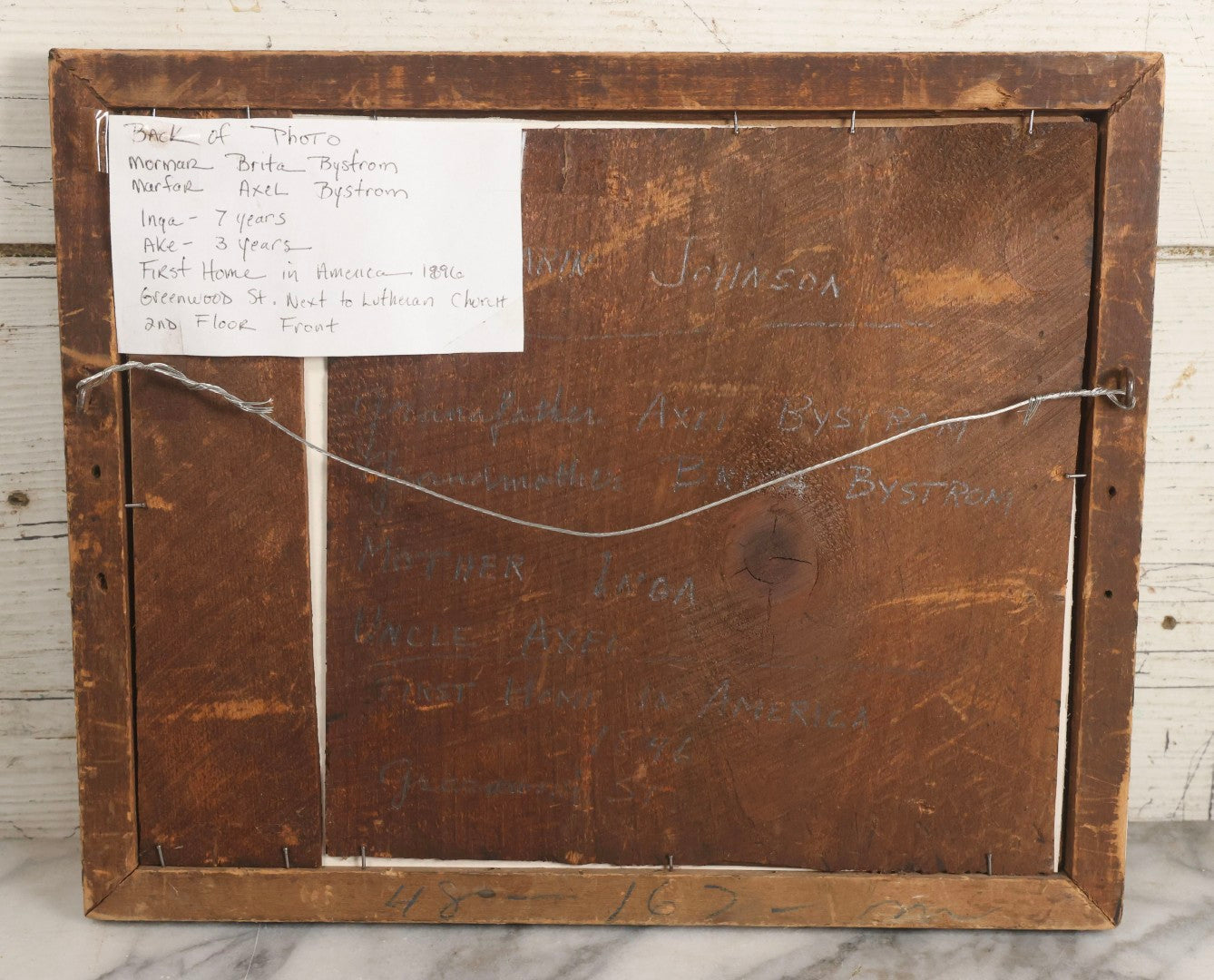 Lot 135 - Antique Framed Photograph Of Multi‑Story Wooden Storefront With Signage Alexstrom Skräddare ("Tailor"), Annotated On Reverse As Bystrom Family's “First Home In America – Greenwood St. Next To Lutheran Church” Dated 1896, 13-3/4" x 11-3/8"