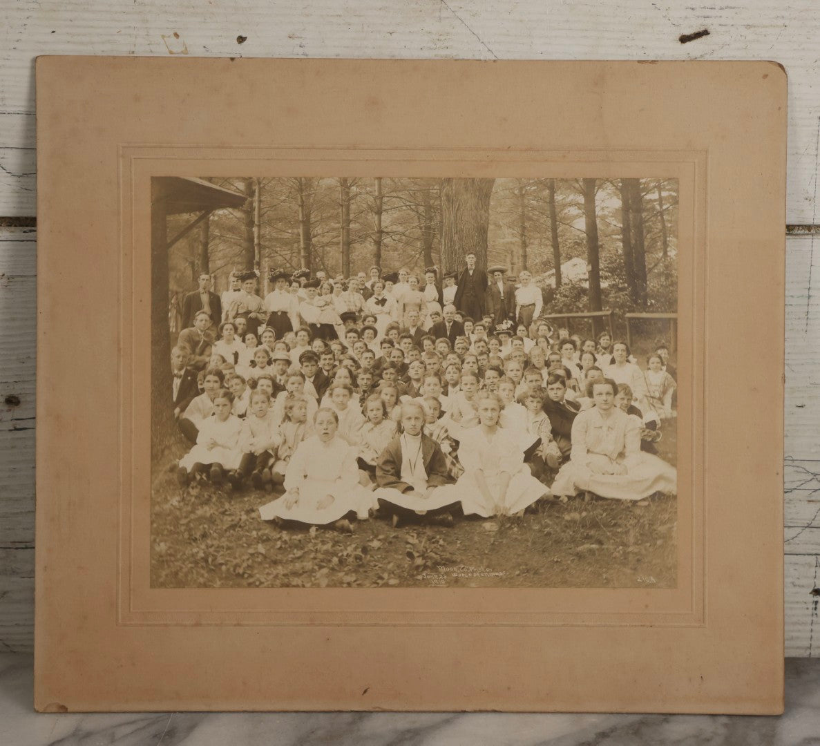 Lot 137 - Antique Boarded Photograph Of Large Group Of Children In Woodland Clearing With Adults Standing Behind, Likely Summer Camp, Photographed By Moon Co. Photo, Worcester, Massachusetts, June 28, 1910