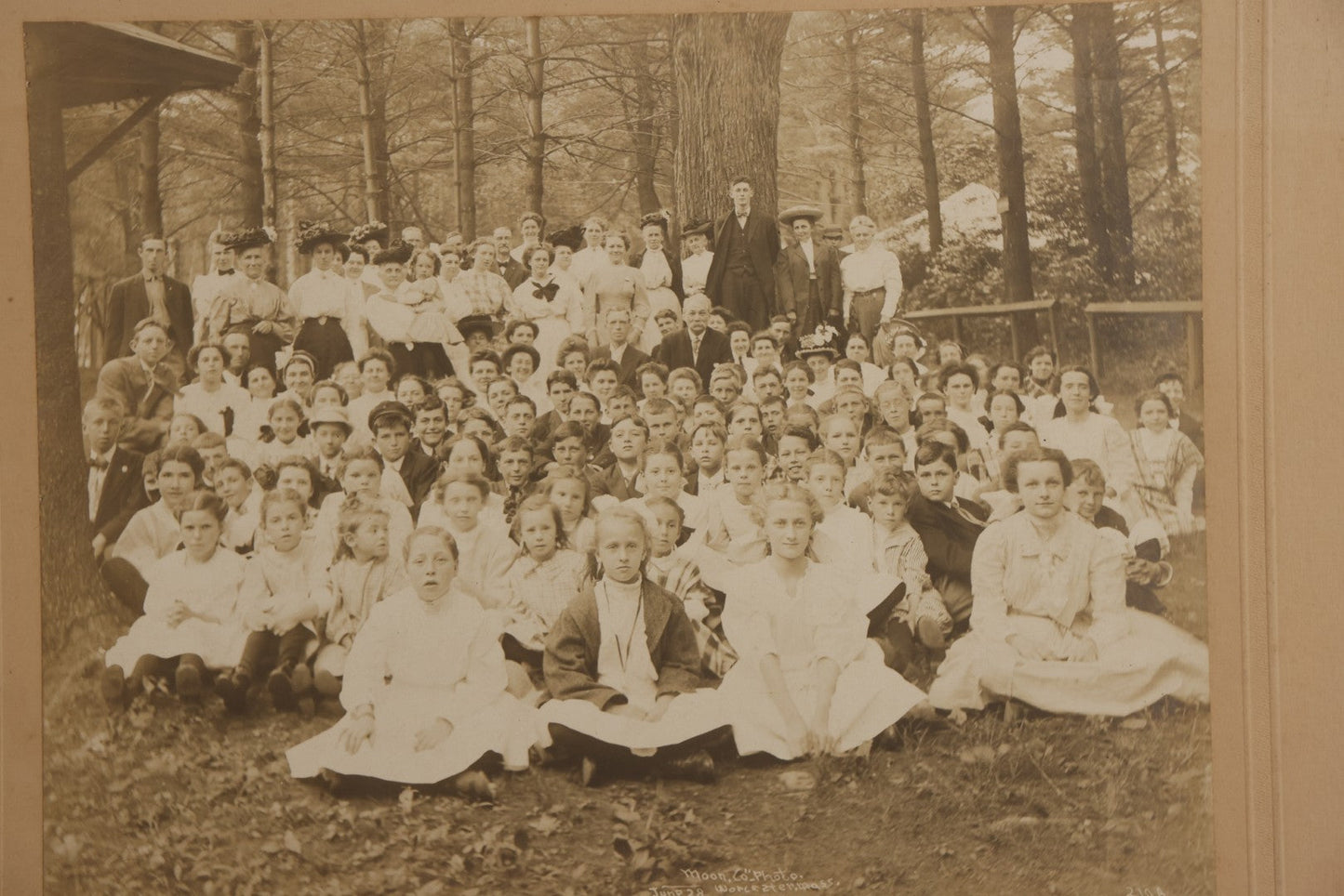 Lot 137 - Antique Boarded Photograph Of Large Group Of Children In Woodland Clearing With Adults Standing Behind, Likely Summer Camp, Photographed By Moon Co. Photo, Worcester, Massachusetts, June 28, 1910