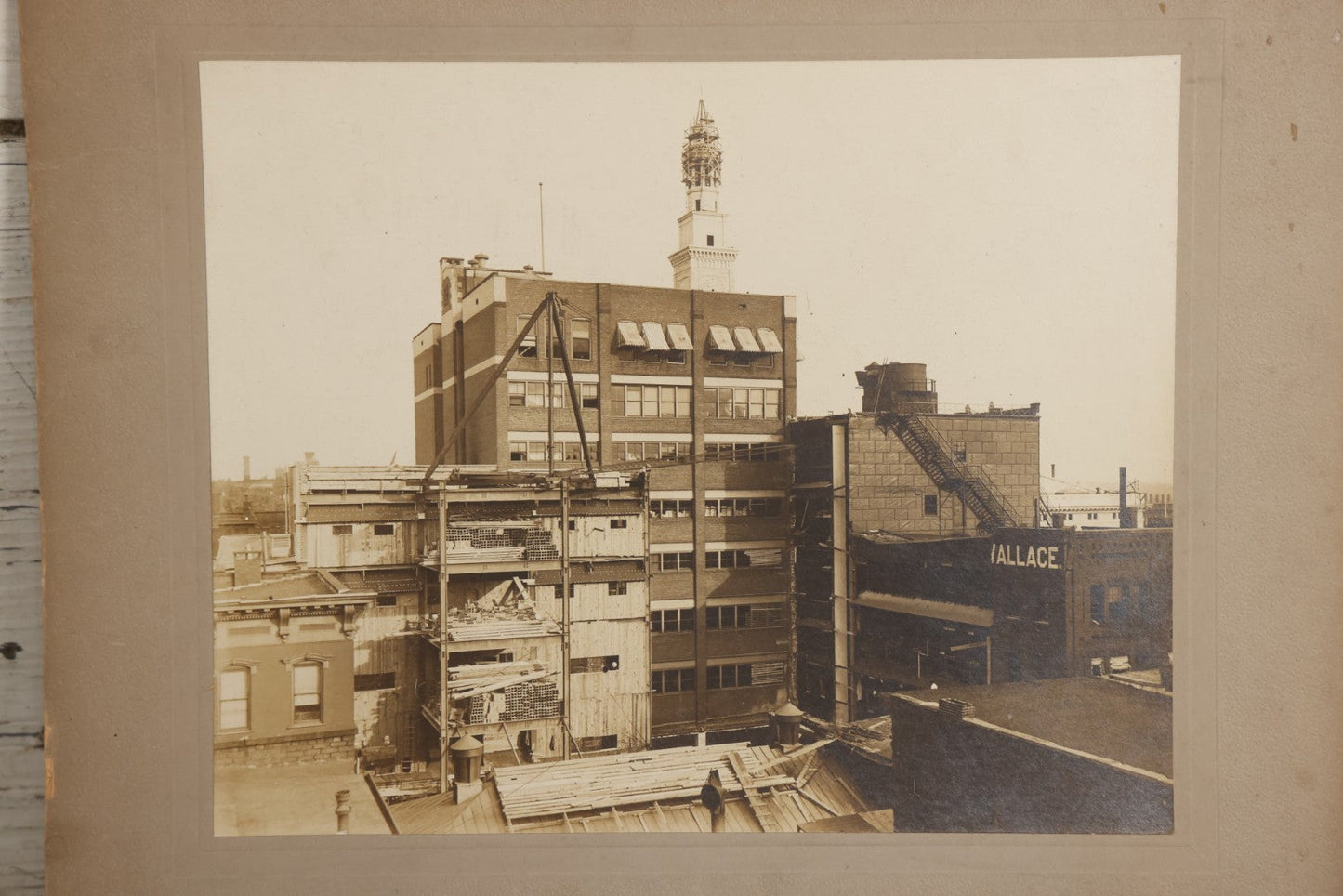 Lot 140 - Antique Boarded Photograph Of Urban Construction Scene With Multi-Story Buildings, Rooftop Water Tank, And “Wallace” Sign Visible