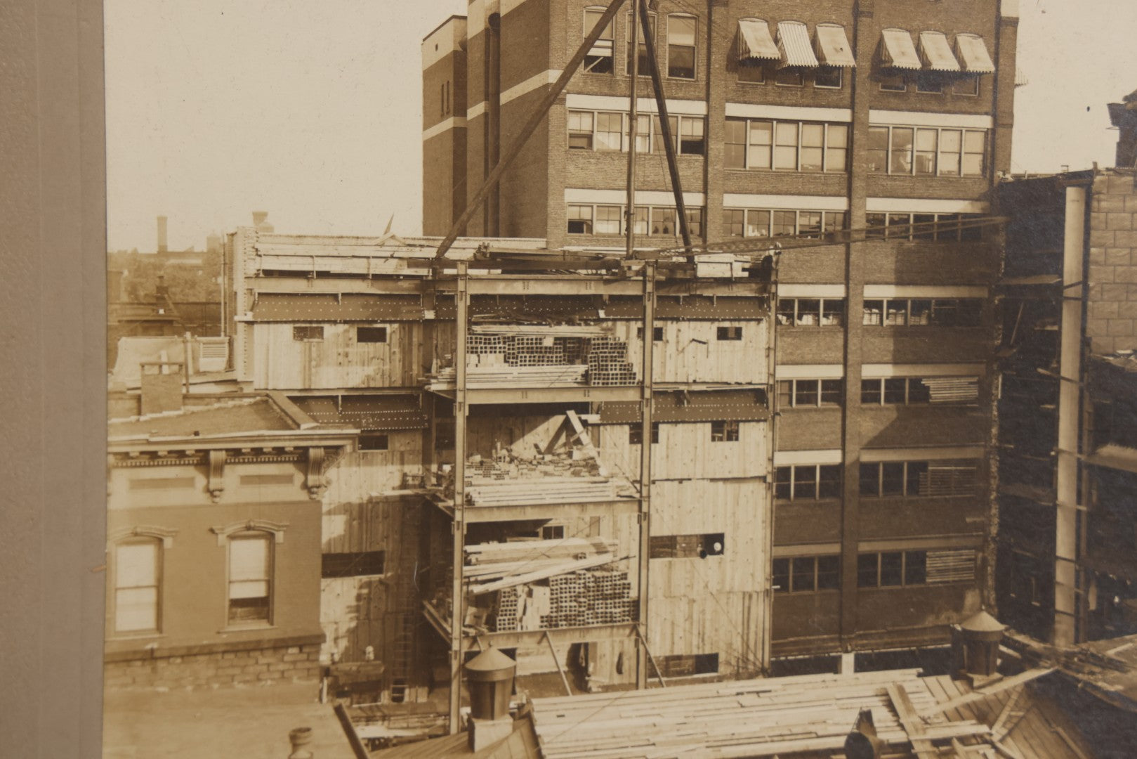 Lot 140 - Antique Boarded Photograph Of Urban Construction Scene With Multi-Story Buildings, Rooftop Water Tank, And “Wallace” Sign Visible