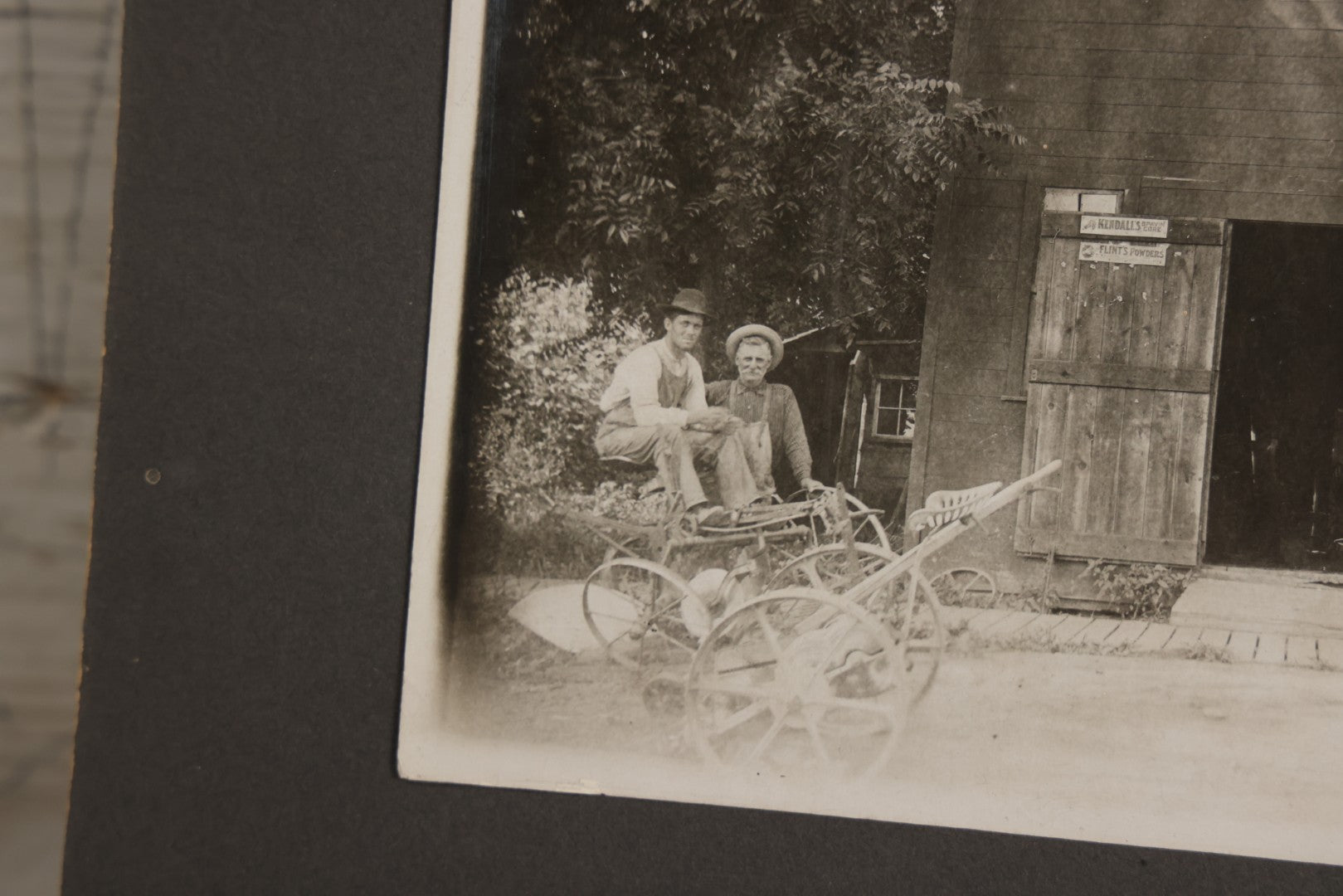 Lot 141 - Antique Boarded Photograph Of Garage With Early Automobile, Kendall's Spavin And Flint's Powder Signage, Three People With Wagon