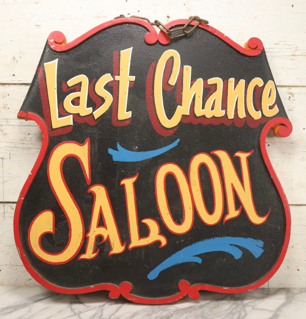 Lot 034 - Double-Sided Wooden Shield-Form Sign With Raised Letters “Burdett 18 College” And Modern Repurposed Side Painted “Last Chance Saloon," Note Missing Corner Scroll Piece And Large Crack In Other Scroll Corner, 25-1/2" x 26"