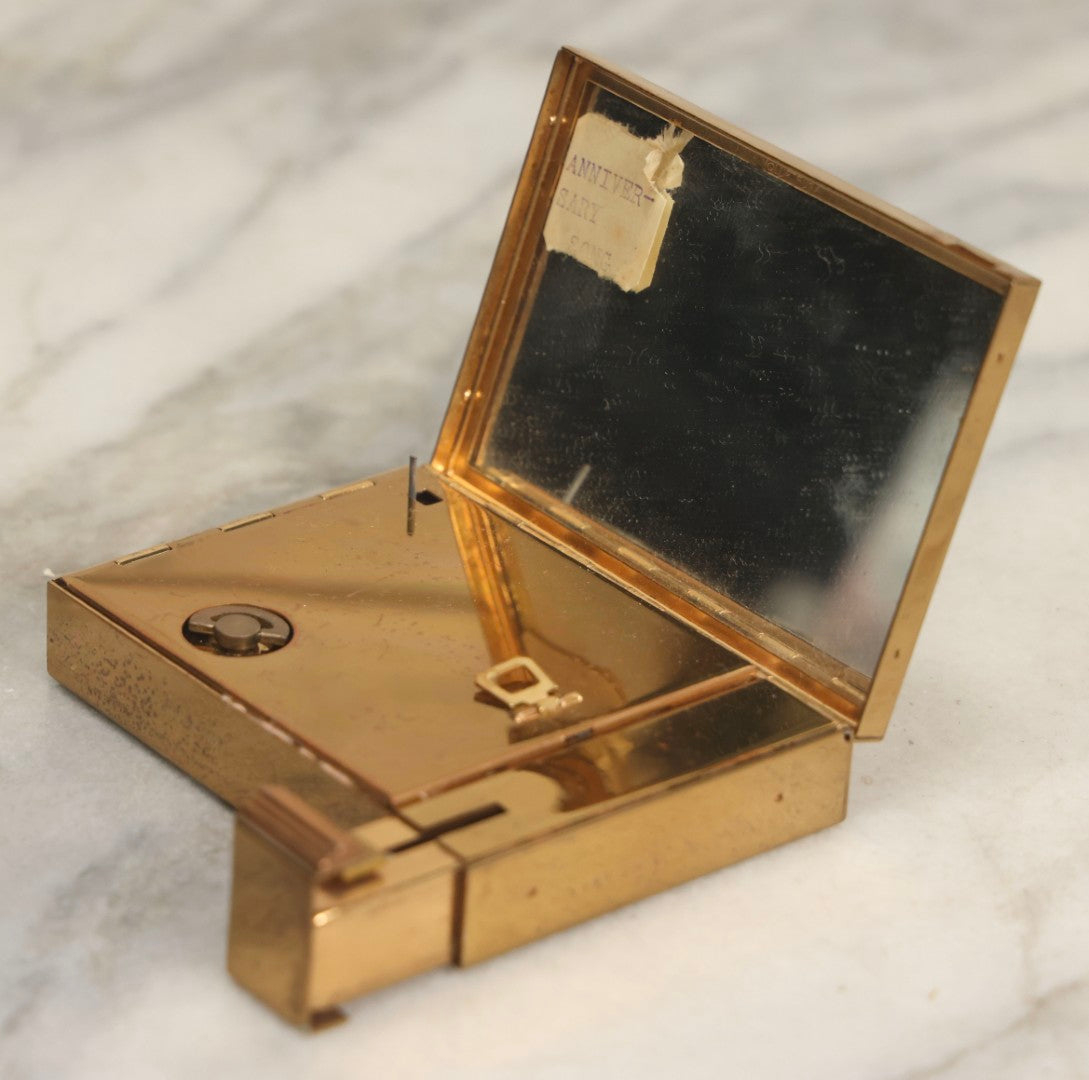 Lot 059 - Vintage Volupte Brass Makeup Compact With Pull-Out Lipstick Holder And Wind Up Musical Box, Made In U.S.A..