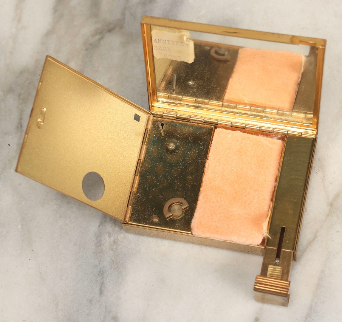 Lot 059 - Vintage Volupte Brass Makeup Compact With Pull-Out Lipstick Holder And Wind Up Musical Box, Made In U.S.A..