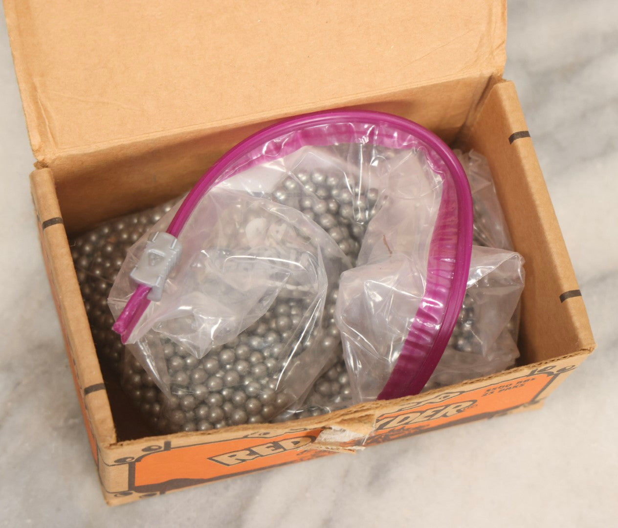 Lot 066 - Grouping Of Three Vintage Advertising Cardboard Boxes With Contents Including Daisy Red Ryder B.B.s Shakespeare Fishing Reel, And Ford Ignition Coil