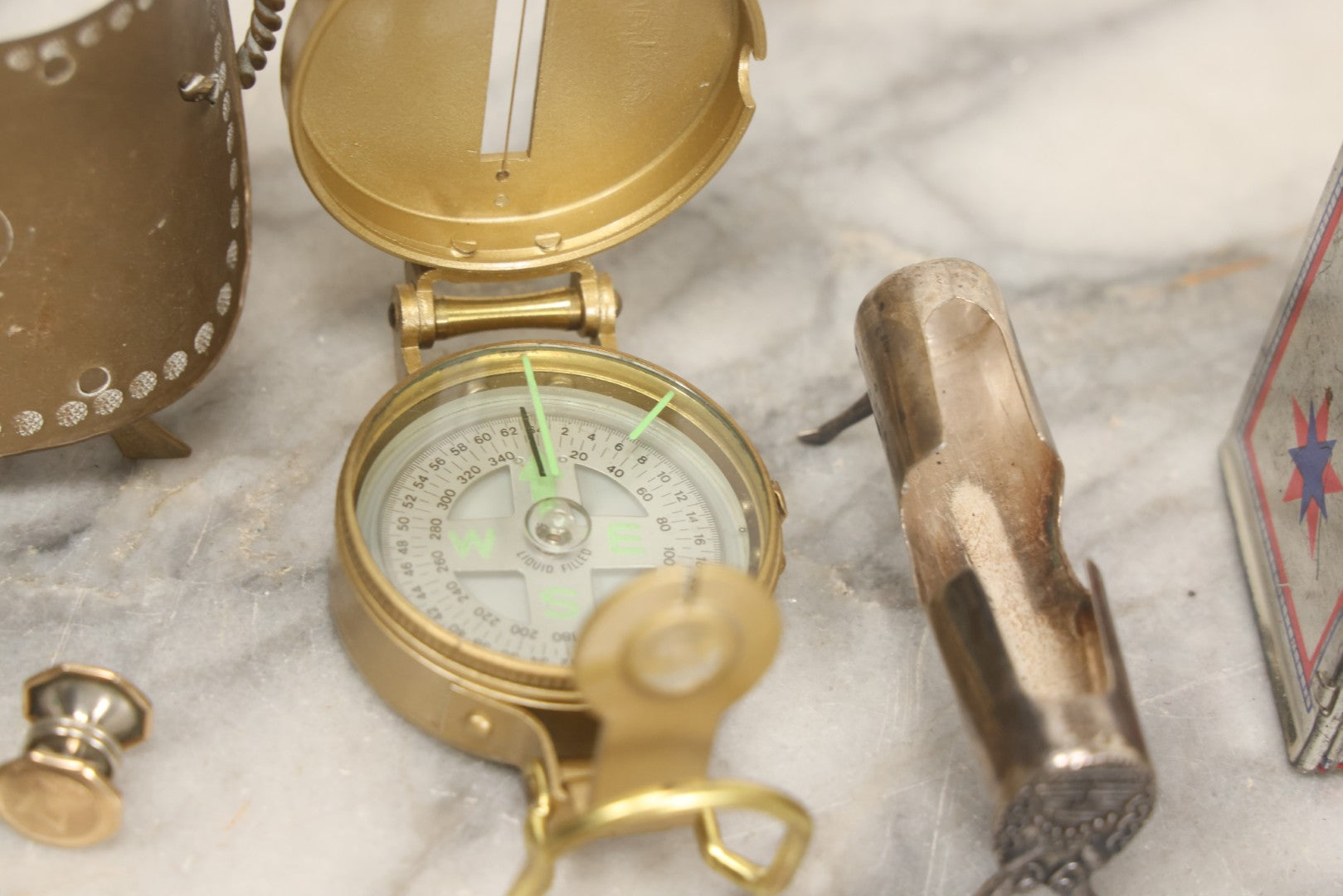 Lot 067 - Grouping Of Eleven Vintage Metal Smalls Including Compass, Wick Trimmer, Measuring Tools, Advertising Opener, Jewelry, Padlock, Tin Toy Bank, And Miniatures