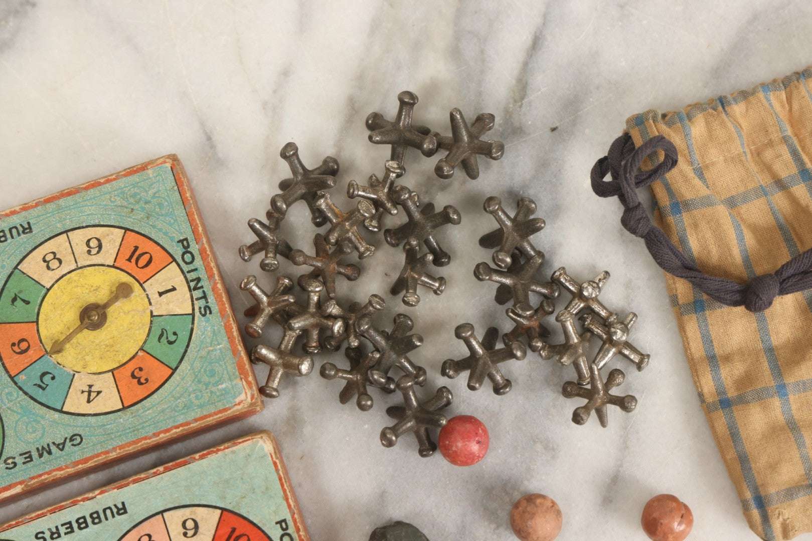 Lot 072 - Grouping Of Vintage Children's Small Games And Toys With Drawstring Sack, Jacks, Clay Marbles, And Two Wood Block Multi-Function Spinners With Paper Dials