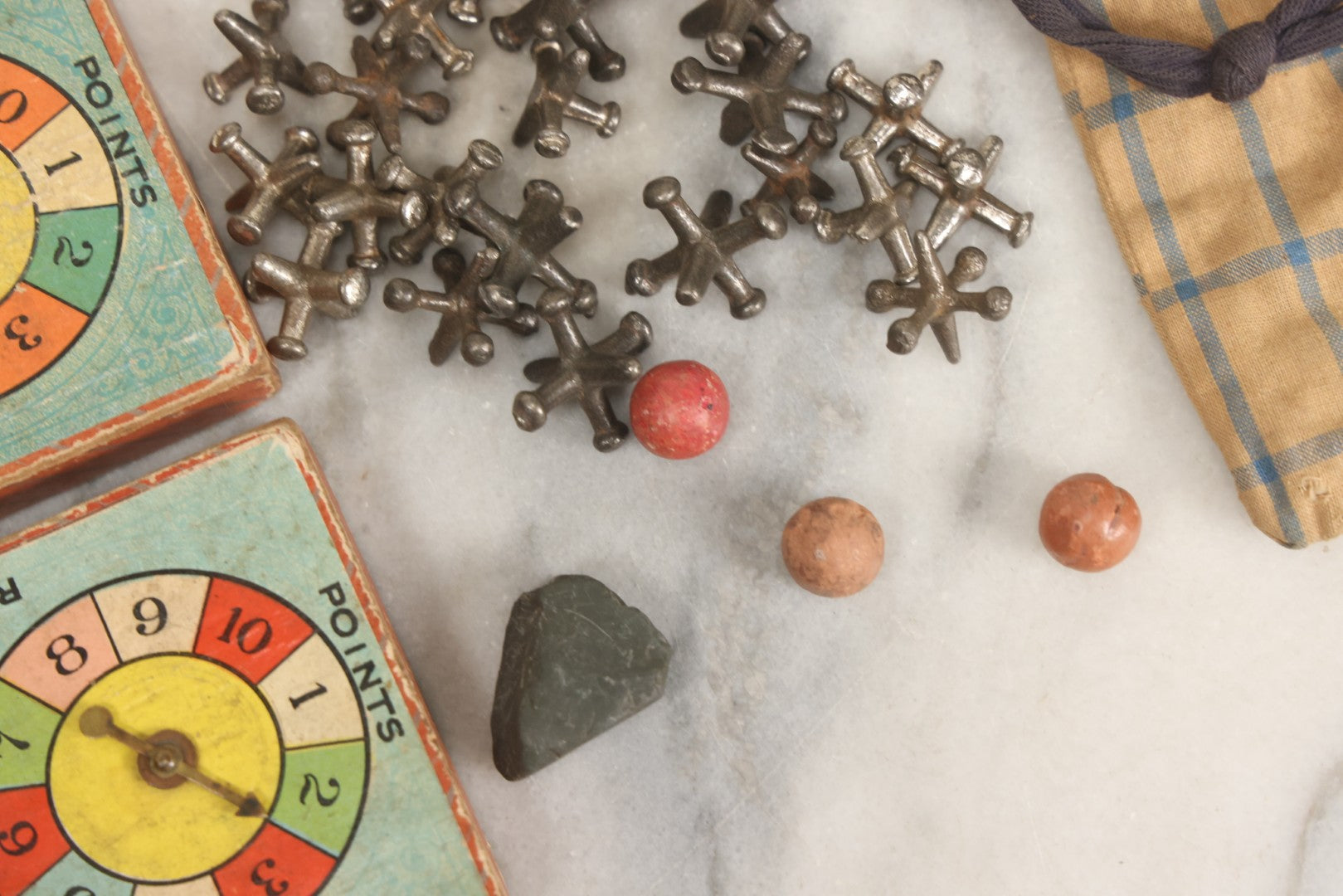 Lot 072 - Grouping Of Vintage Children's Small Games And Toys With Drawstring Sack, Jacks, Clay Marbles, And Two Wood Block Multi-Function Spinners With Paper Dials