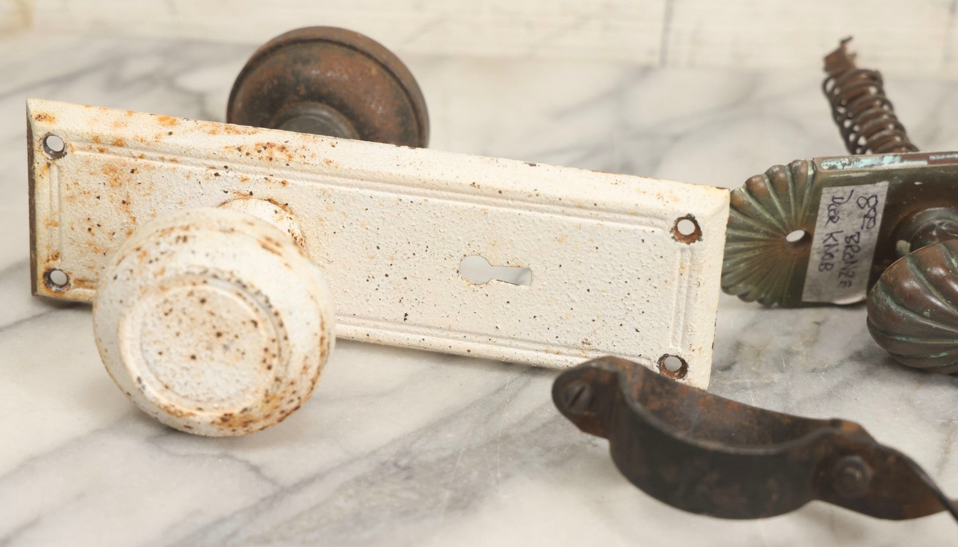 Lot 077 - Grouping Of Four Antique Hardware Items Including Metal Bell, Door Knobs, Escutcheon, And Autodesk Steering Wheel Bracket