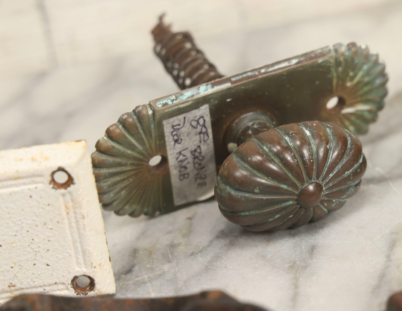 Lot 077 - Grouping Of Four Antique Hardware Items Including Metal Bell, Door Knobs, Escutcheon, And Autodesk Steering Wheel Bracket