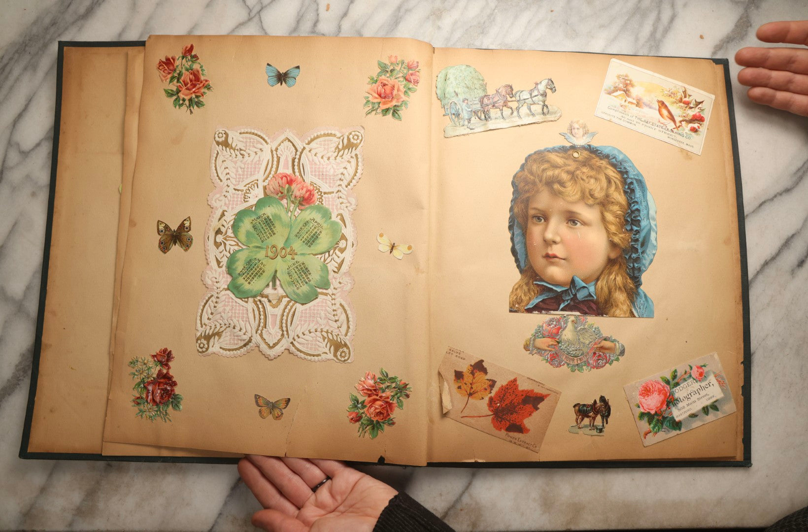 Lot 096 - Antique "The Nonpareil" Scrapbook, Puppies Illustration On Cover, With 100+ Trade Cards, Die Cuts, And Greeting Cards Featuring Children, Butterflies, And Flowers, Circa 1900-1906, Note Binding Detached