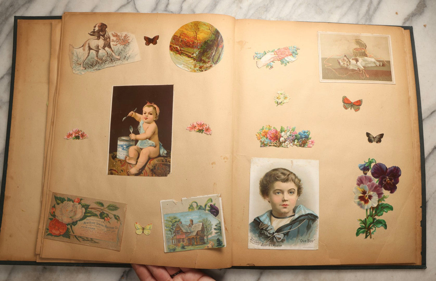 Lot 096 - Antique "The Nonpareil" Scrapbook, Puppies Illustration On Cover, With 100+ Trade Cards, Die Cuts, And Greeting Cards Featuring Children, Butterflies, And Flowers, Circa 1900-1906, Note Binding Detached