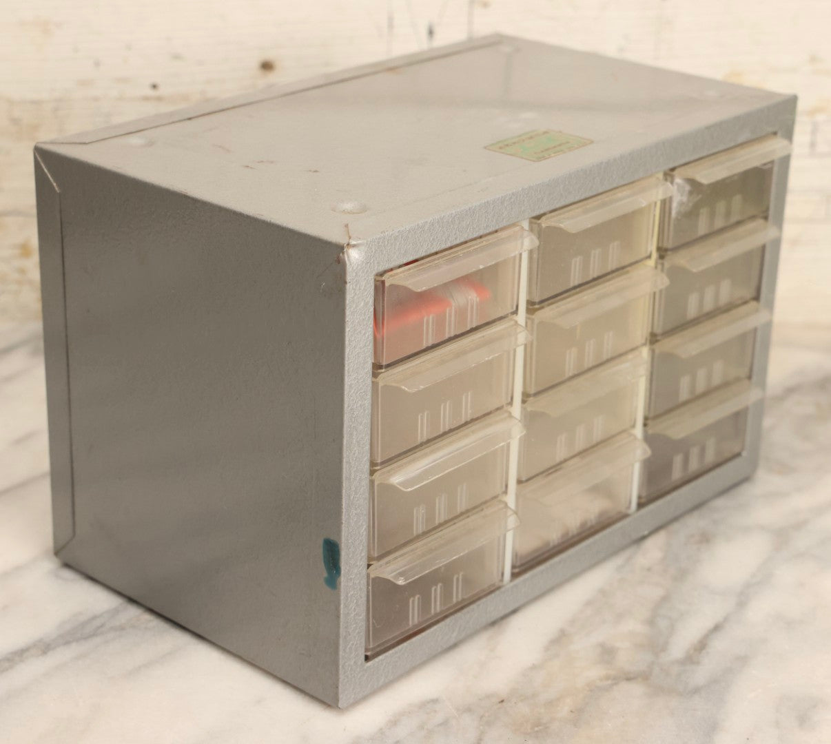 Lot 123 - Vintage A-M Cabinets Silver Metal 21-Drawer Parts Organizer With Original Paper Advertising And Labeling Supplies, Manufactured By Akro-Mils, Akron, Ohio