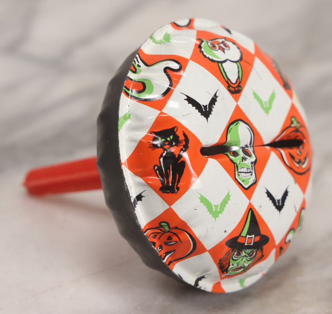 Lot 048 - Vintage Round Halloween Tin Lithograph Noisemaker With Orange And White Checkered Pattern Featuring Black Cat, Witch, Ghost, Bat, Skull, And Jack-O'-Lantern J.O.L. Characters