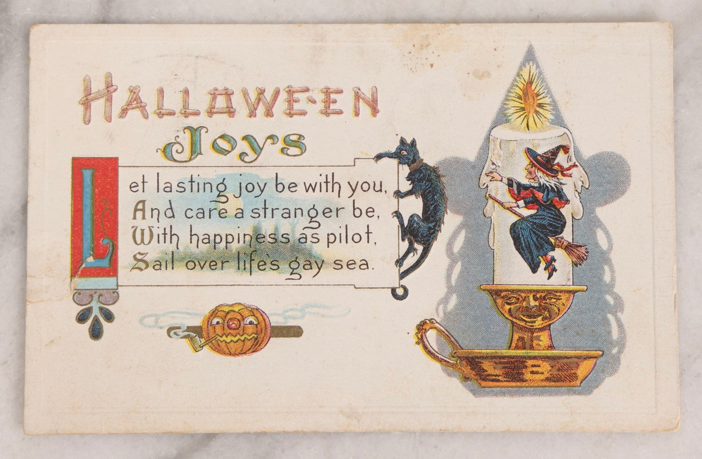 Lot 052 - Antique Embossed Halloween Postcard Featuring Witch On Candle With Black Cat, Jack-O-Lantern J.O.L. Smoking A Pipe, Faces In The Candlestand And Candle Wax, And Witch's Shadow, Made In U.S.A.., Postmarked October 31, 1914