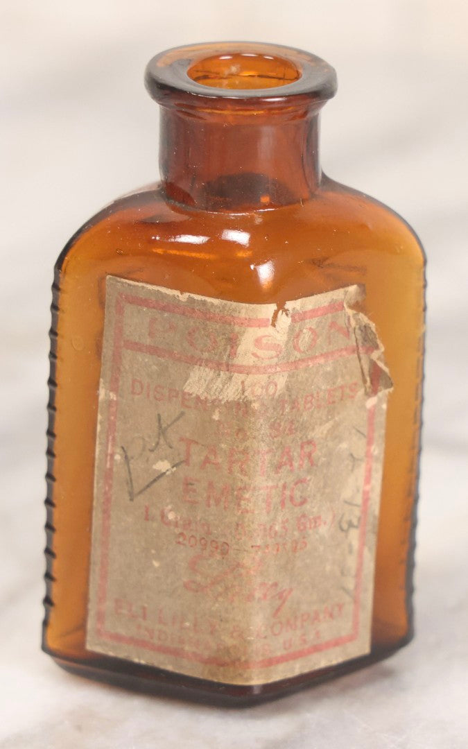 Lot 084 - Amber Poison Bottle With Poison Ribs, Tartar Emetic Paper Label, Eli Lilly & Co., Indianapolis, Indiana