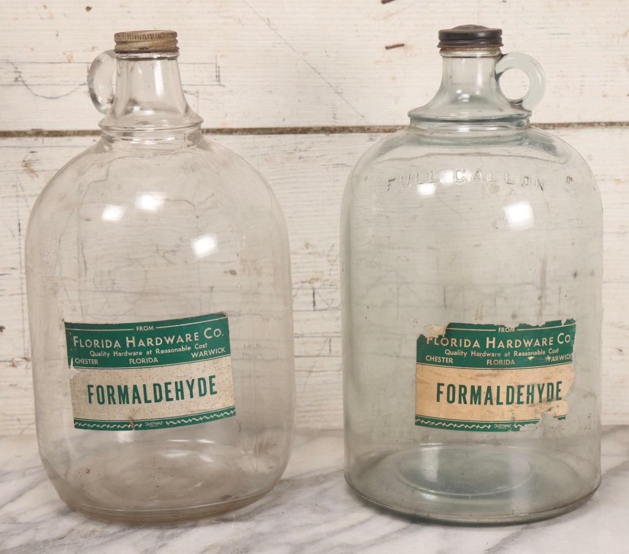 Lot 087 - Pair Of Vintage Clear Glass Jugs With Later-Applied Green “Formaldehyde” Paper Labels From Florida Hardware Co.