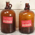 Lot 088 - Pair Of Vintage Amber Glass Jugs With Later-Applied Red “Formaldehyde” Paper Labels From Florida Hardware Co., 11-1/2" H Each
