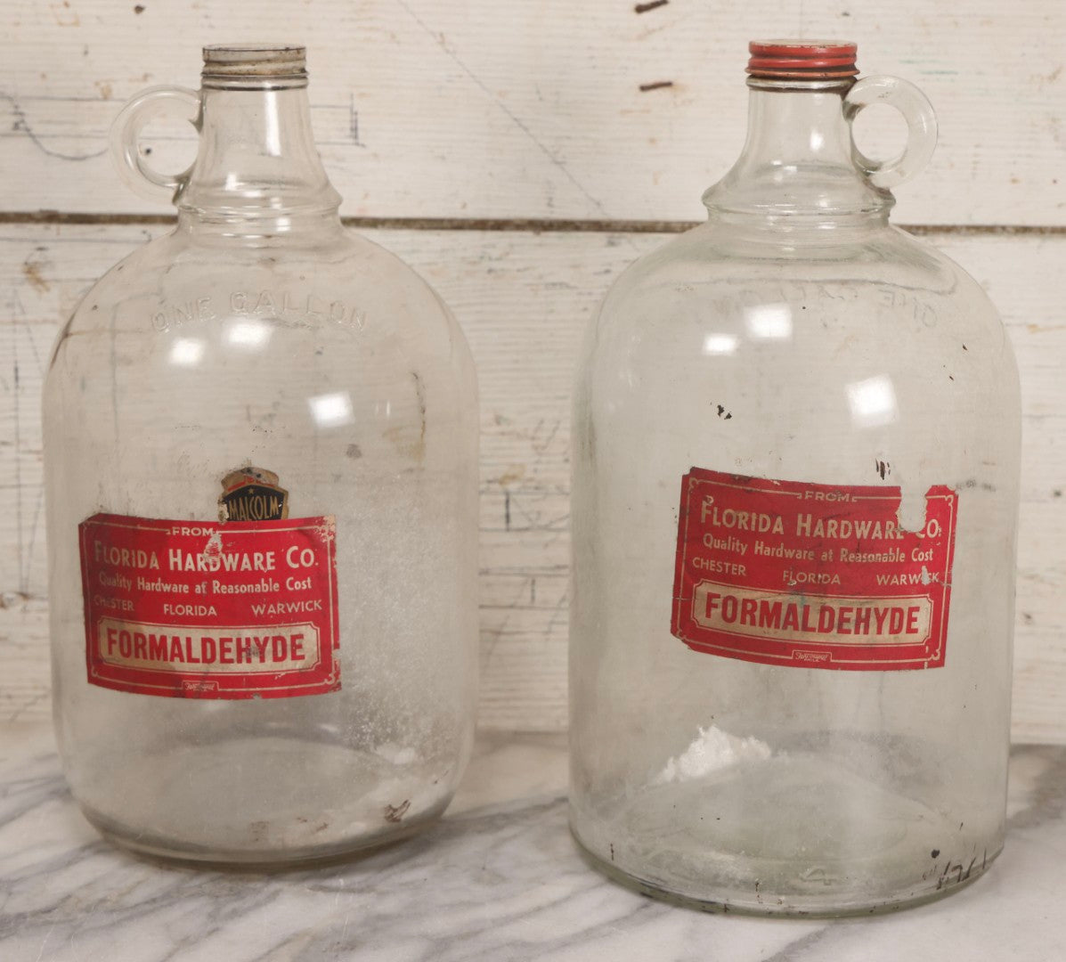 Lot 089 - Pair Of Vintage Clear Glass Jugs With Later-Applied Red “Formaldehyde” Paper Labels From Florida Hardware Co.