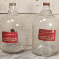 Lot 089 - Pair Of Vintage Clear Glass Jugs With Later-Applied Red “Formaldehyde” Paper Labels From Florida Hardware Co., 11-1/2" H Each