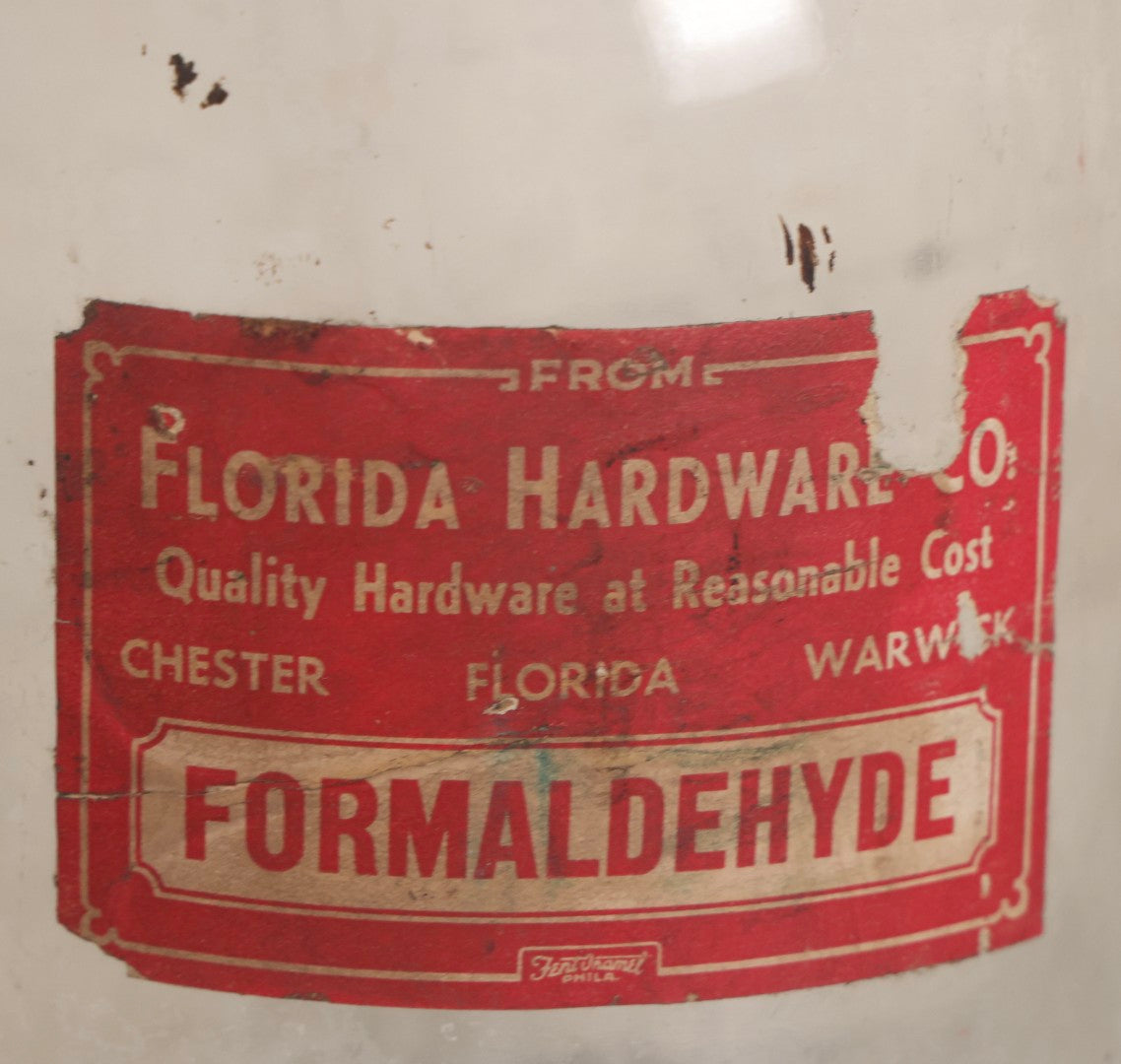 Lot 089 - Pair Of Vintage Clear Glass Jugs With Later-Applied Red “Formaldehyde” Paper Labels From Florida Hardware Co.