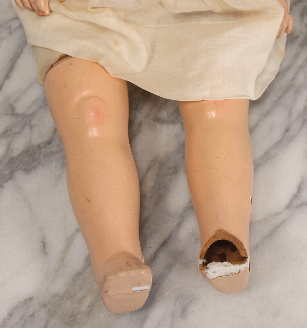 Lot 093 - Vintage Composition Baby Doll With Yellowed Sleep Eyes And Original Outfit, Missing Wig, Damaged Foot