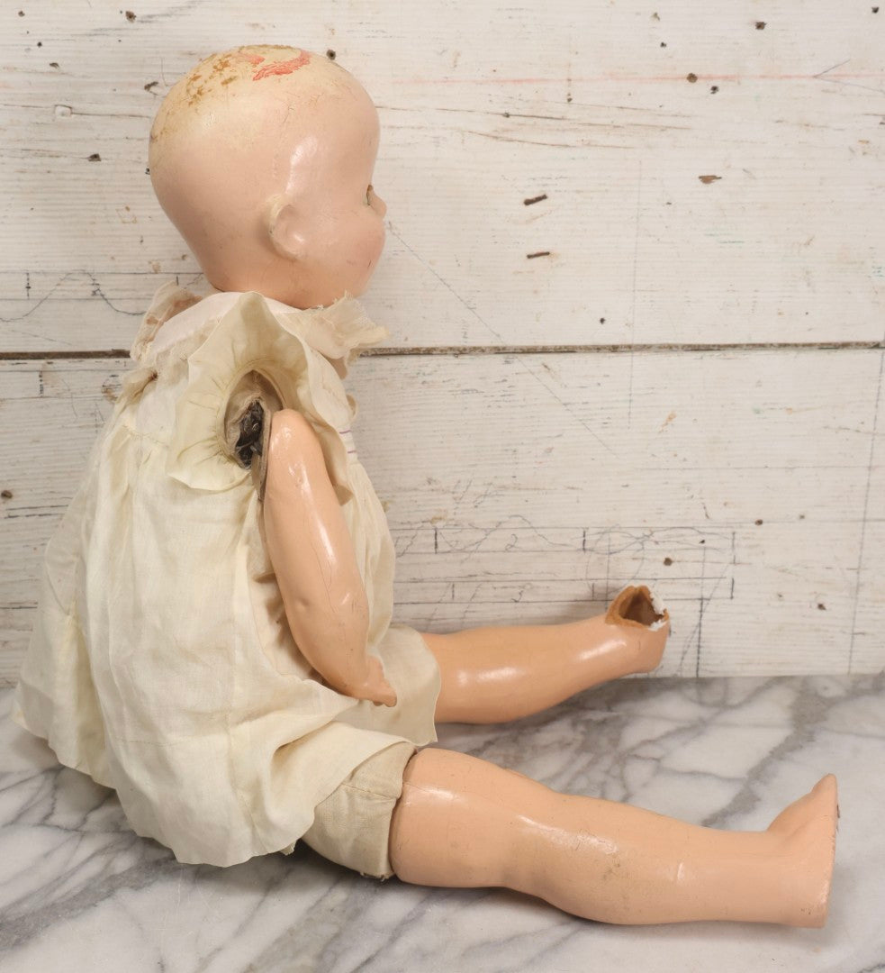 Lot 093 - Vintage Composition Baby Doll With Yellowed Sleep Eyes And Original Outfit, Missing Wig, Damaged Foot