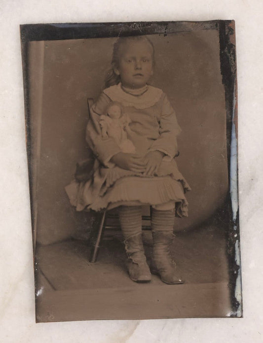 Lot 141 - Single Antique Tintype Photograph Of A Young Girl Seated In A Small Wooden Chair With Her Doll Tucked Under Her Arm