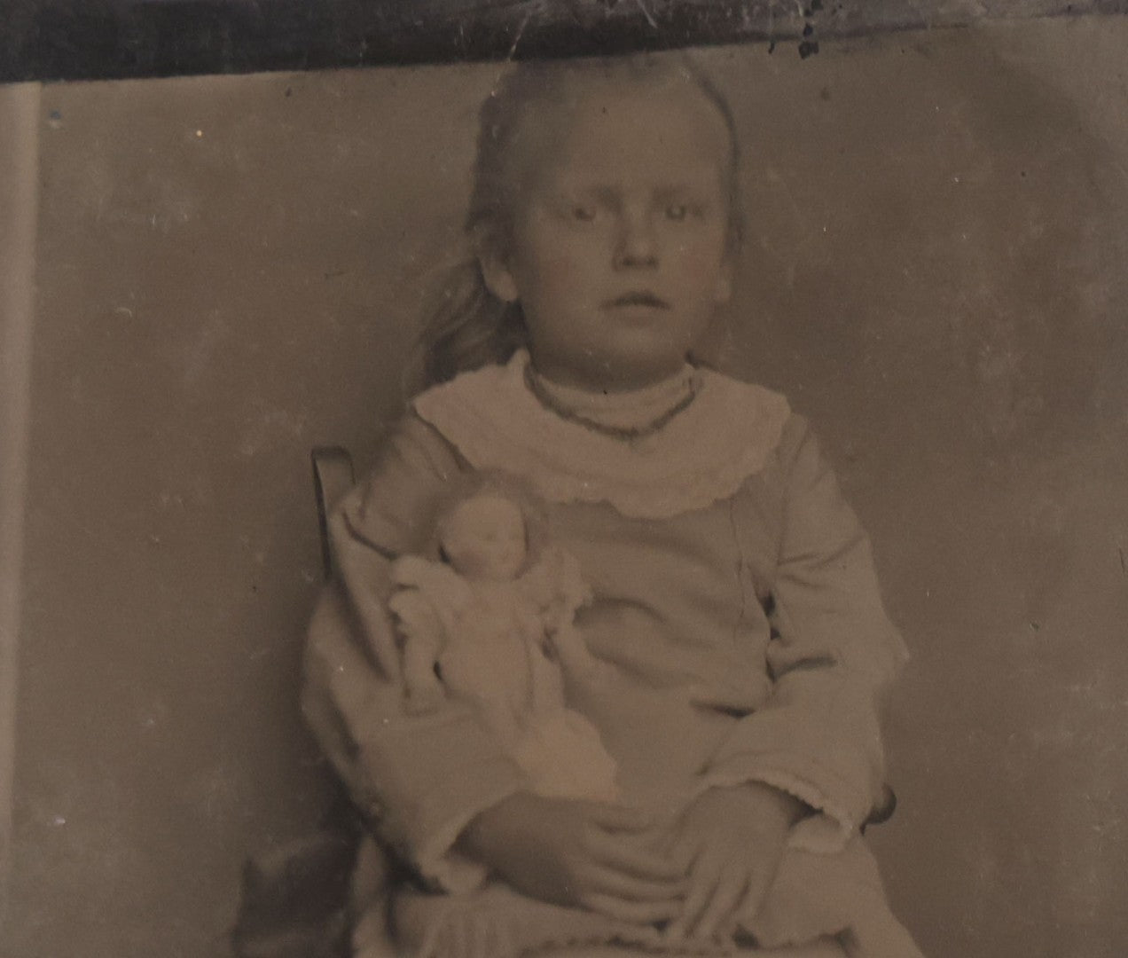 Lot 141 - Single Antique Tintype Photograph Of A Young Girl Seated In A Small Wooden Chair With Her Doll Tucked Under Her Arm