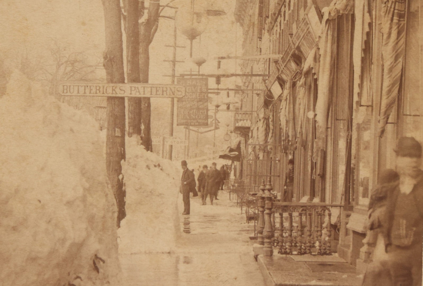 Lot 150 - Antique Boudoir-Sized Cabinet Card Photograph Depicting Street Scene Aftermath Of Great Blizzard Of 1888, New York City, With Snow Banks, Pedestrians, And "Butterick's Patterns" Storefront Visible