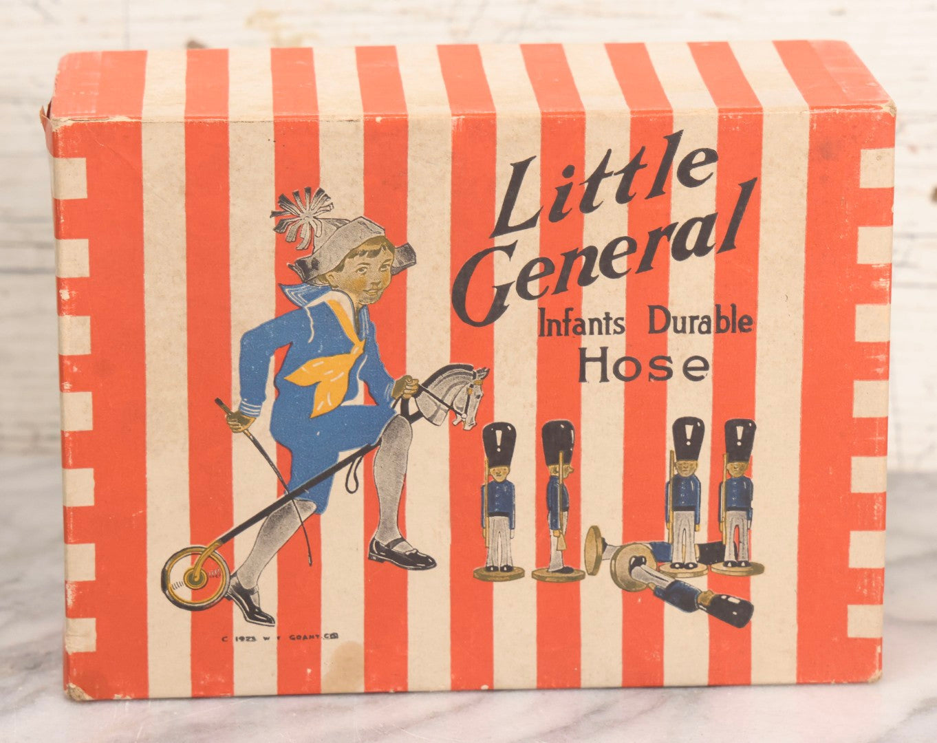 Lot 262 - Trio Of Vintage And Antique Advertising Pieces Including Grass Seed Tin, Camel Tire Tube Repair Kit, And “Little General Infants Durable Hose” Undergarments Box, W.T. Grant Co., 1923