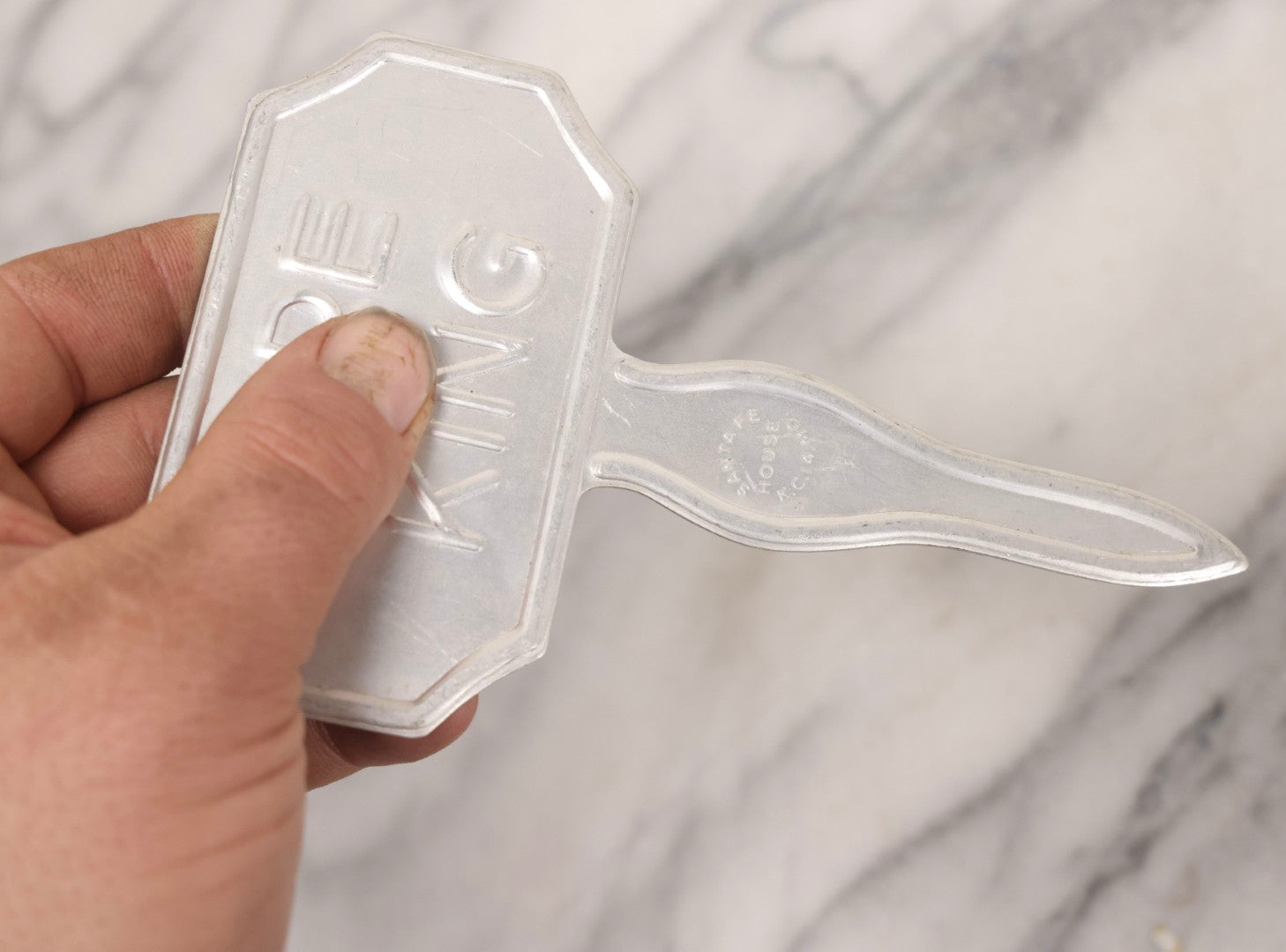 Lot 275 - Grouping Of Six Vintage Metal Objects Including Fire King Aluminum Rose Garden Marker, Cast Iron Meat Tenderizer, Schrader Tire Pressure Gauge, Lucky Dime Register Bank, Esterbrook Clip, And Mechanics Pal Tape Measure