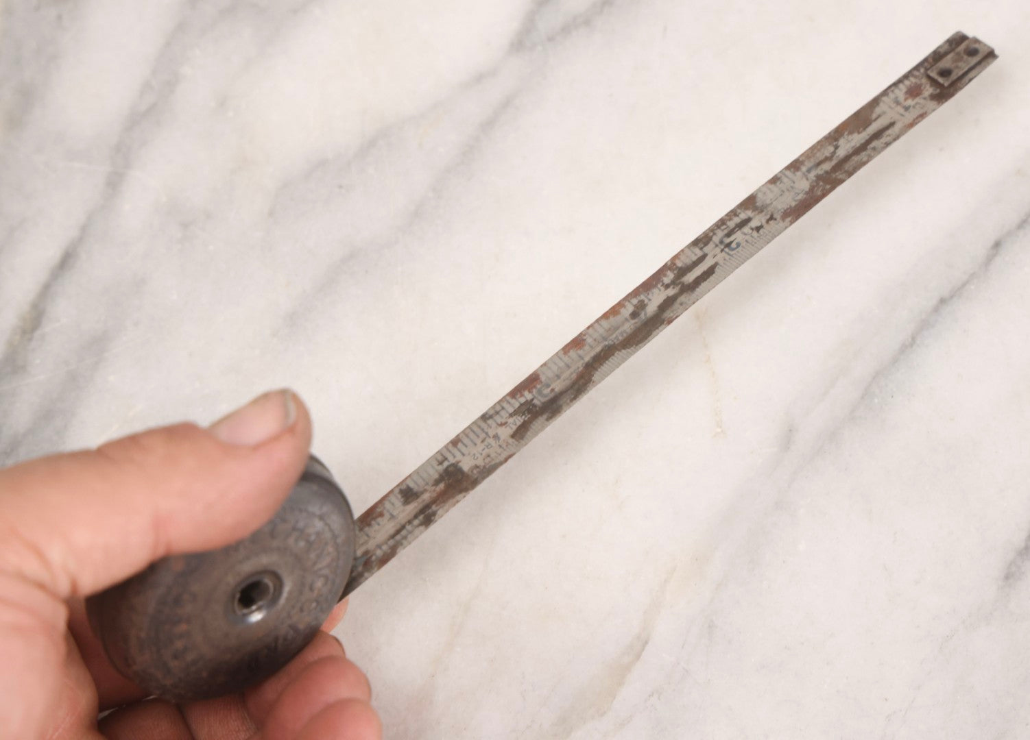 Lot 275 - Grouping Of Six Vintage Metal Objects Including Fire King Aluminum Rose Garden Marker, Cast Iron Meat Tenderizer, Schrader Tire Pressure Gauge, Lucky Dime Register Bank, Esterbrook Clip, And Mechanics Pal Tape Measure