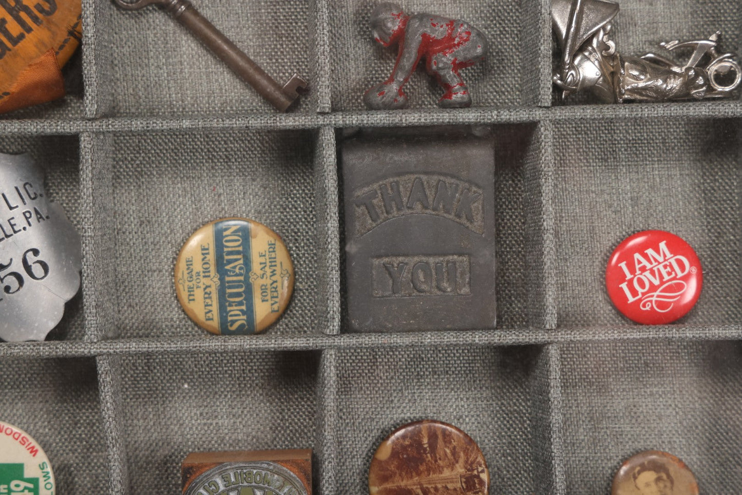 Lot 276 - Modern Display Case With Vintage Smalls And Advertising Pieces Including Candy Machine Door, Bicycle License, Pinback Buttons, Printing Block, And Metal Toy Football Player