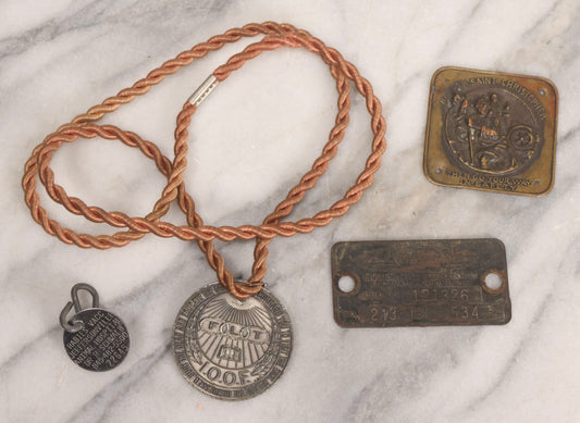 Lot 281 - Grouping Of Four Vintage Metal Badges Including St. Christopher Automobile Safety Badge, I.O.O.F.. Odd Fellows Badge, New Idea Product Tag, And Dog Rabies Tag