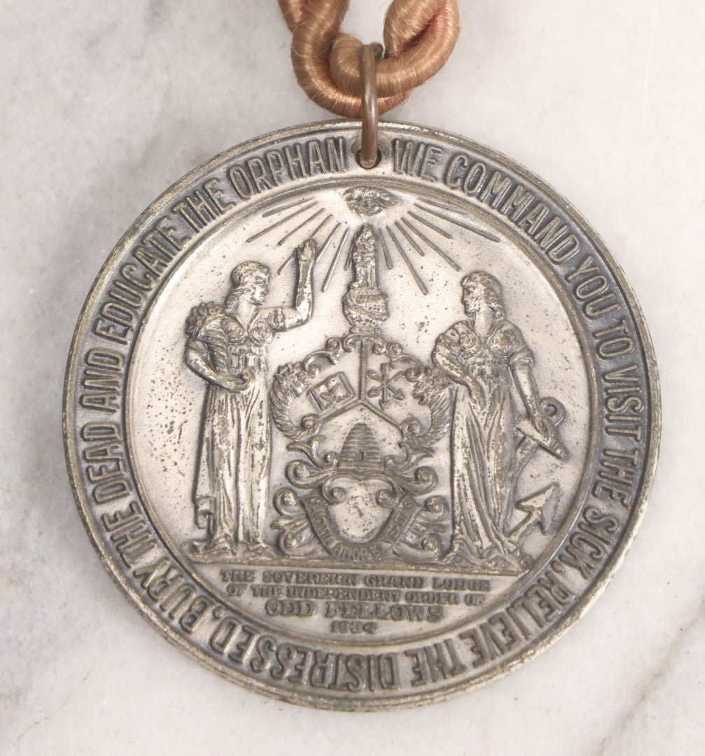 Lot 281 - Grouping Of Four Vintage Metal Badges Including St. Christopher Automobile Safety Badge, I.O.O.F.. Odd Fellows Badge, New Idea Product Tag, And Dog Rabies Tag